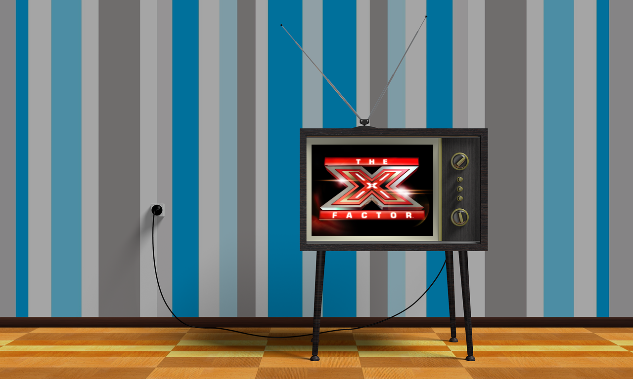 An old-fashioned TV with The X Factor on the screen 