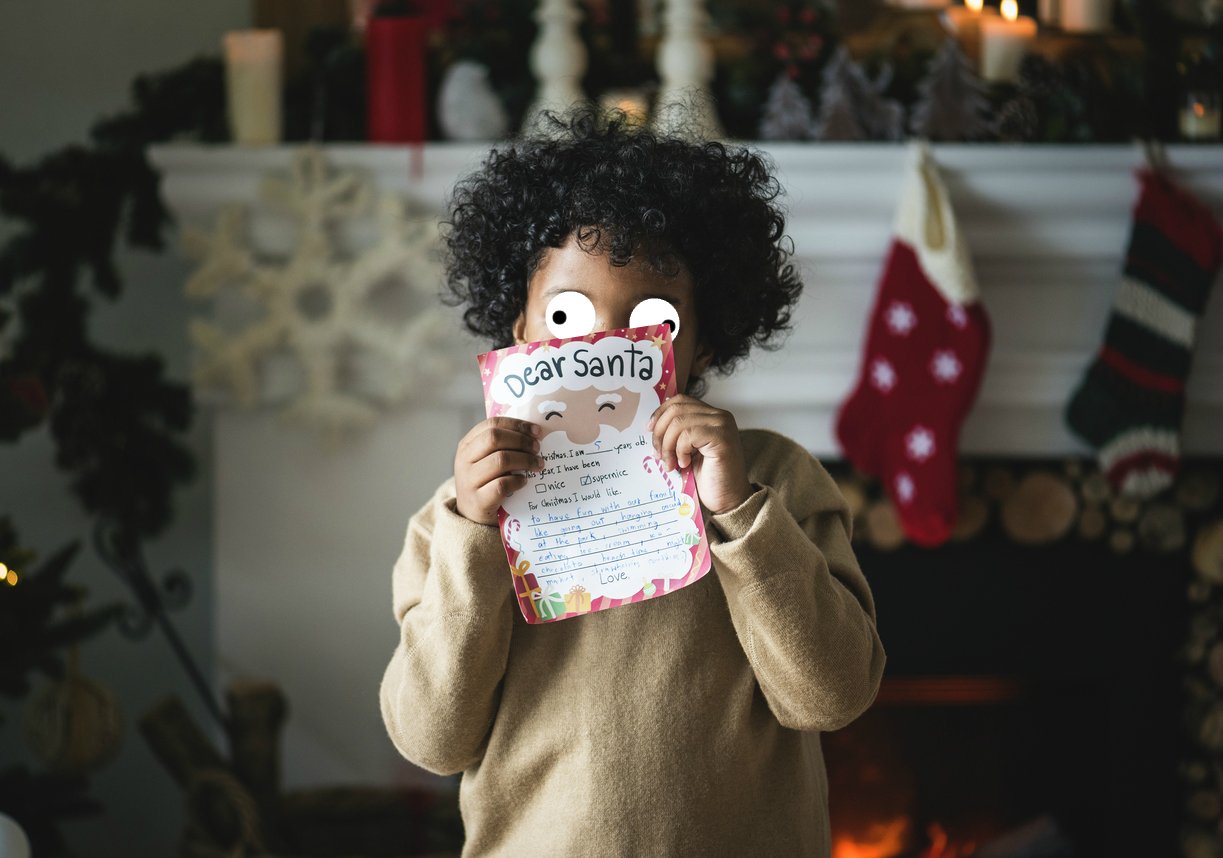 A child holds a letter to Santa