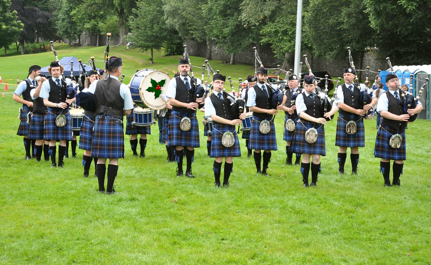 A group of bagpipe players performing in a field