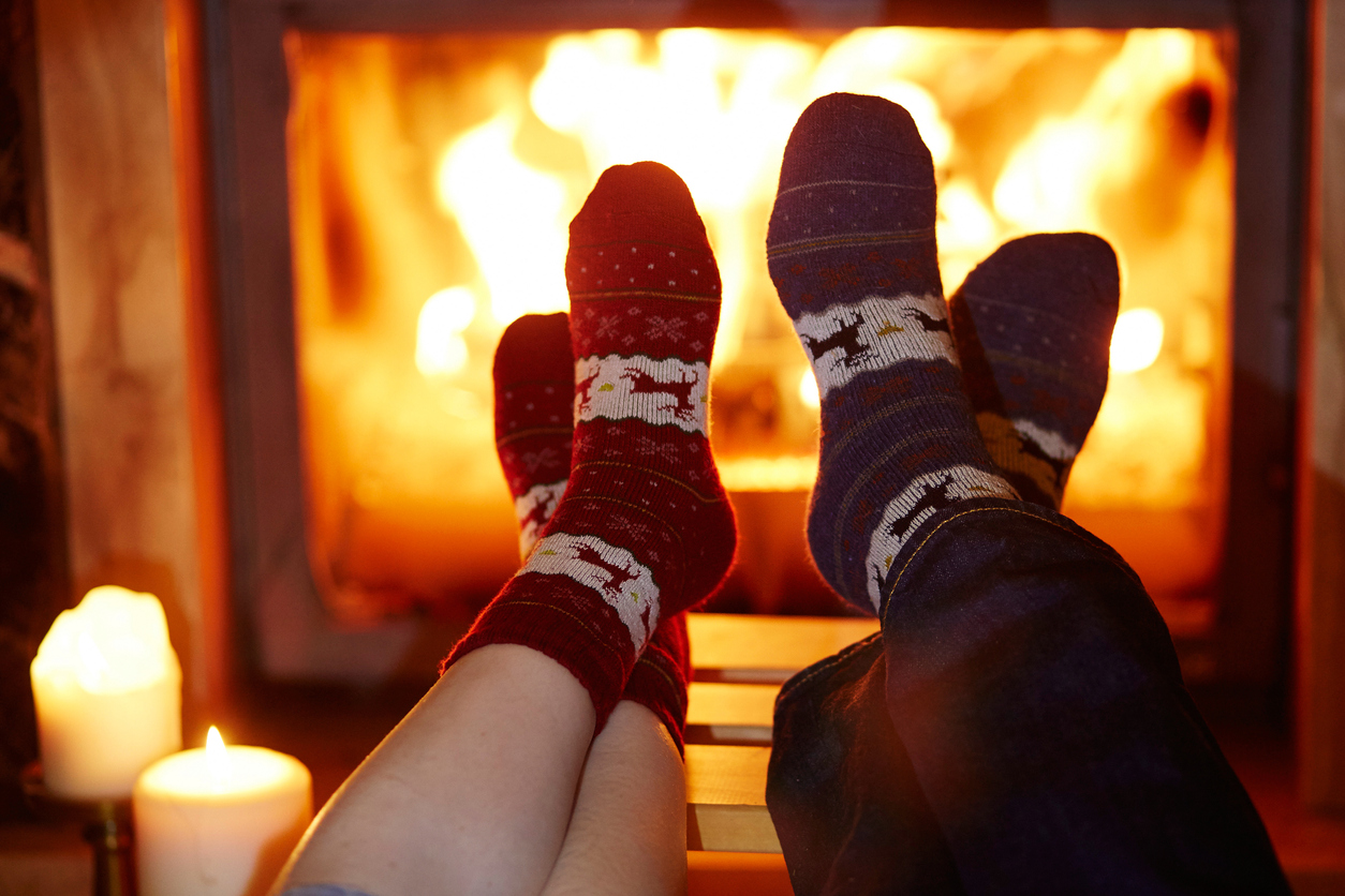 Two pairs of feet getting toasty by the fire