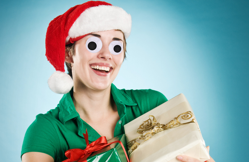 A woman in a Santa hat, holding a parcel
