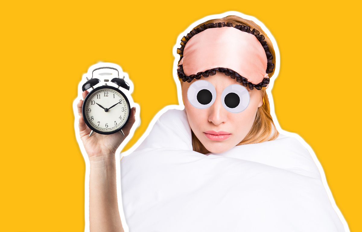 A sleepy woman holds an alarm clock