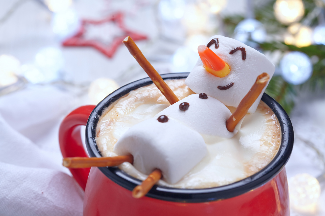 A marshmallow person relaxing in a mug of hot chocolate
