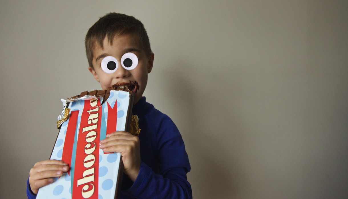 A child eating a massive bar of chocolate
