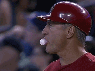 A baseball player blowing a rubbish bubble 