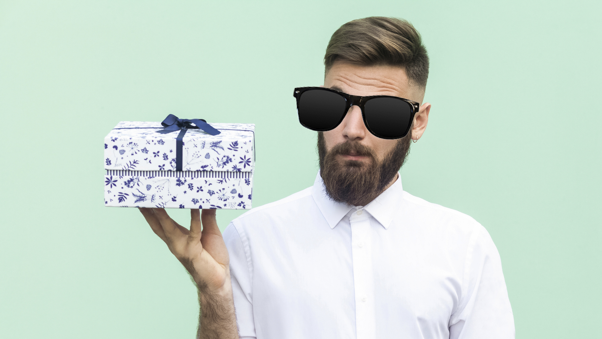 A man in sunglasses looking at a box