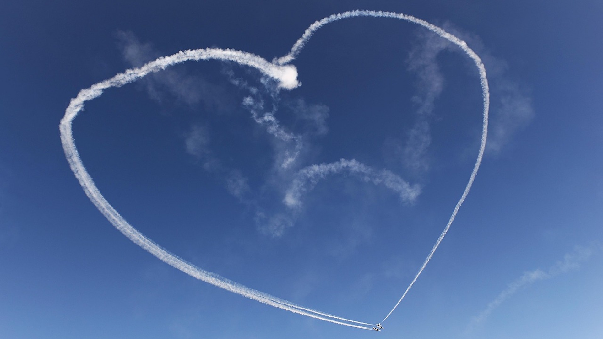 Stunt planes drawing a heart in the sky