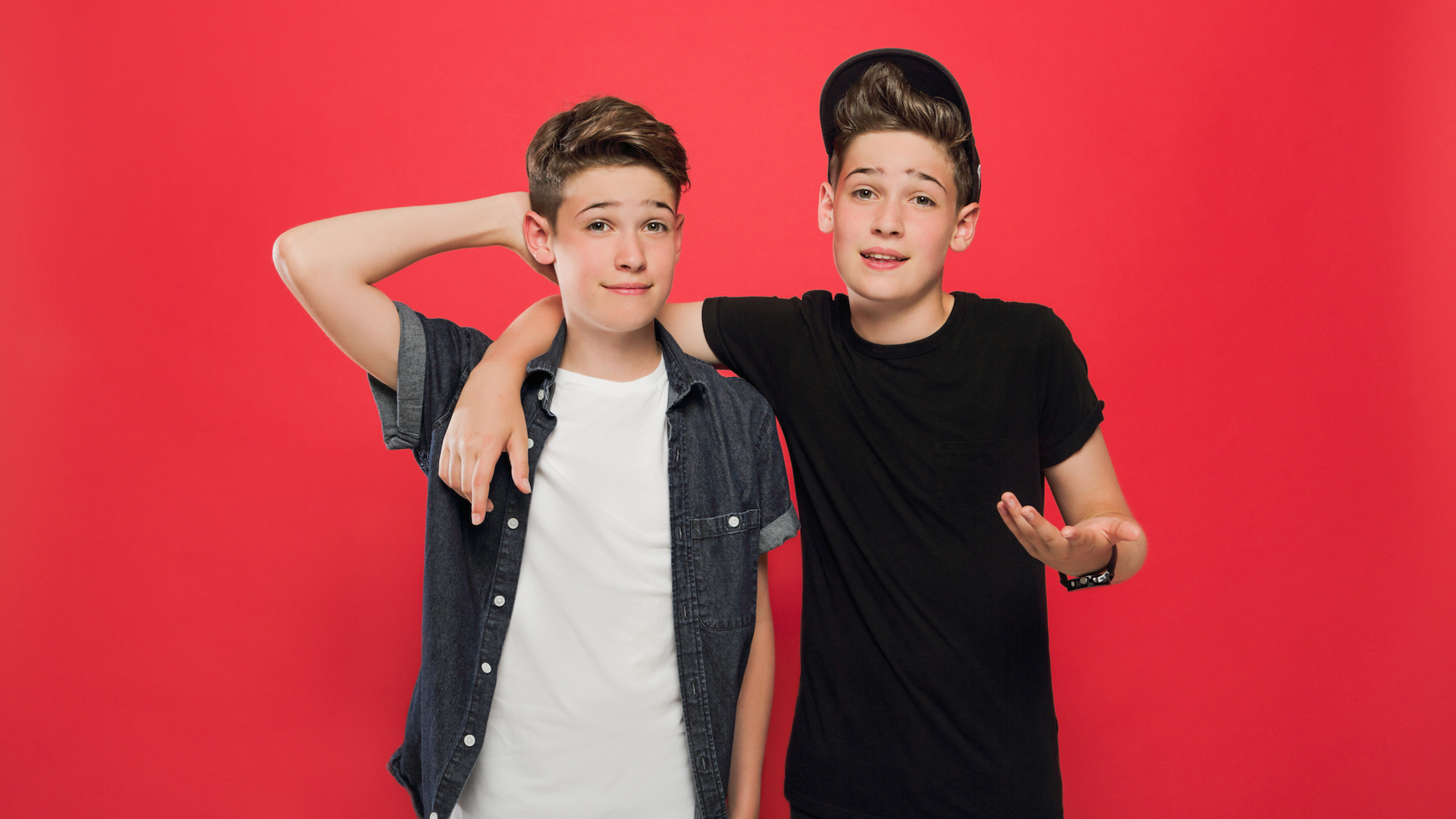 Max and Harvey pose against a red background