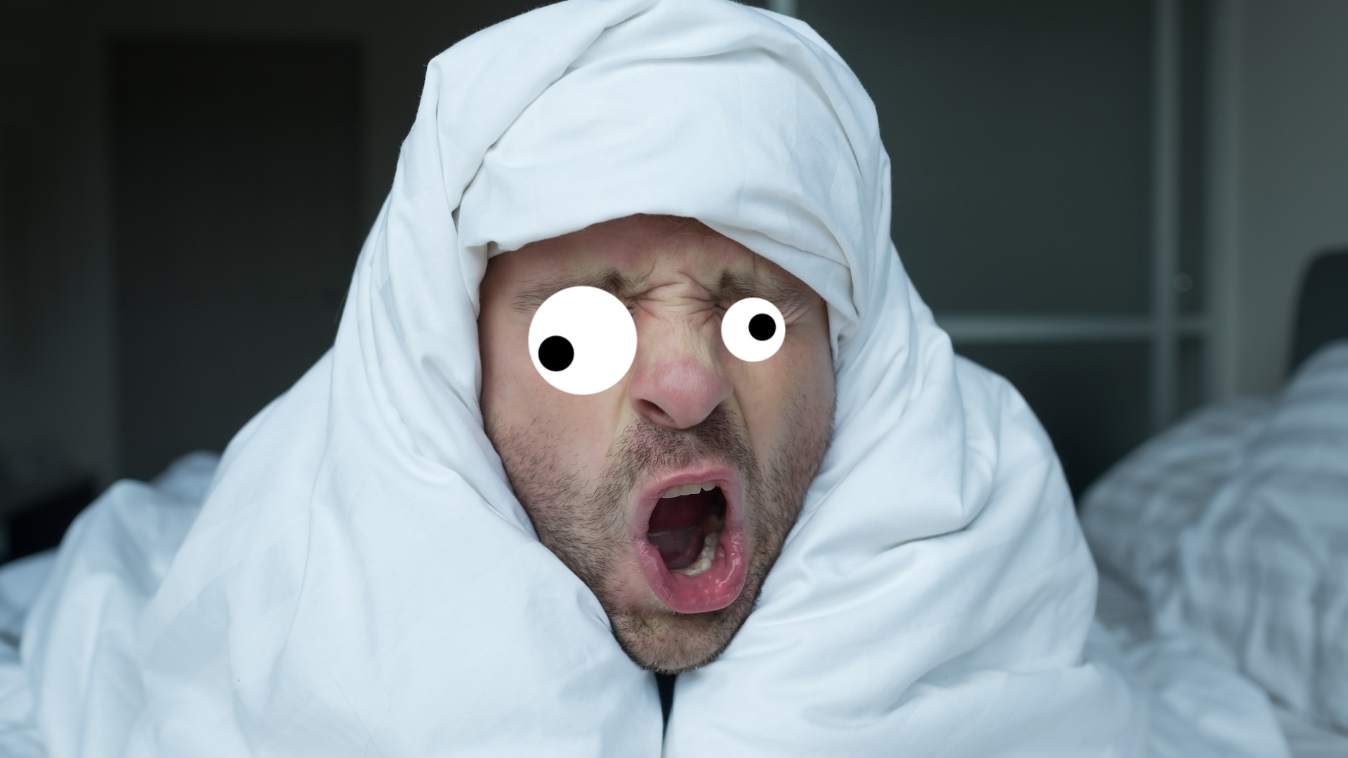 A man wrapped in a duvet trying to wake up