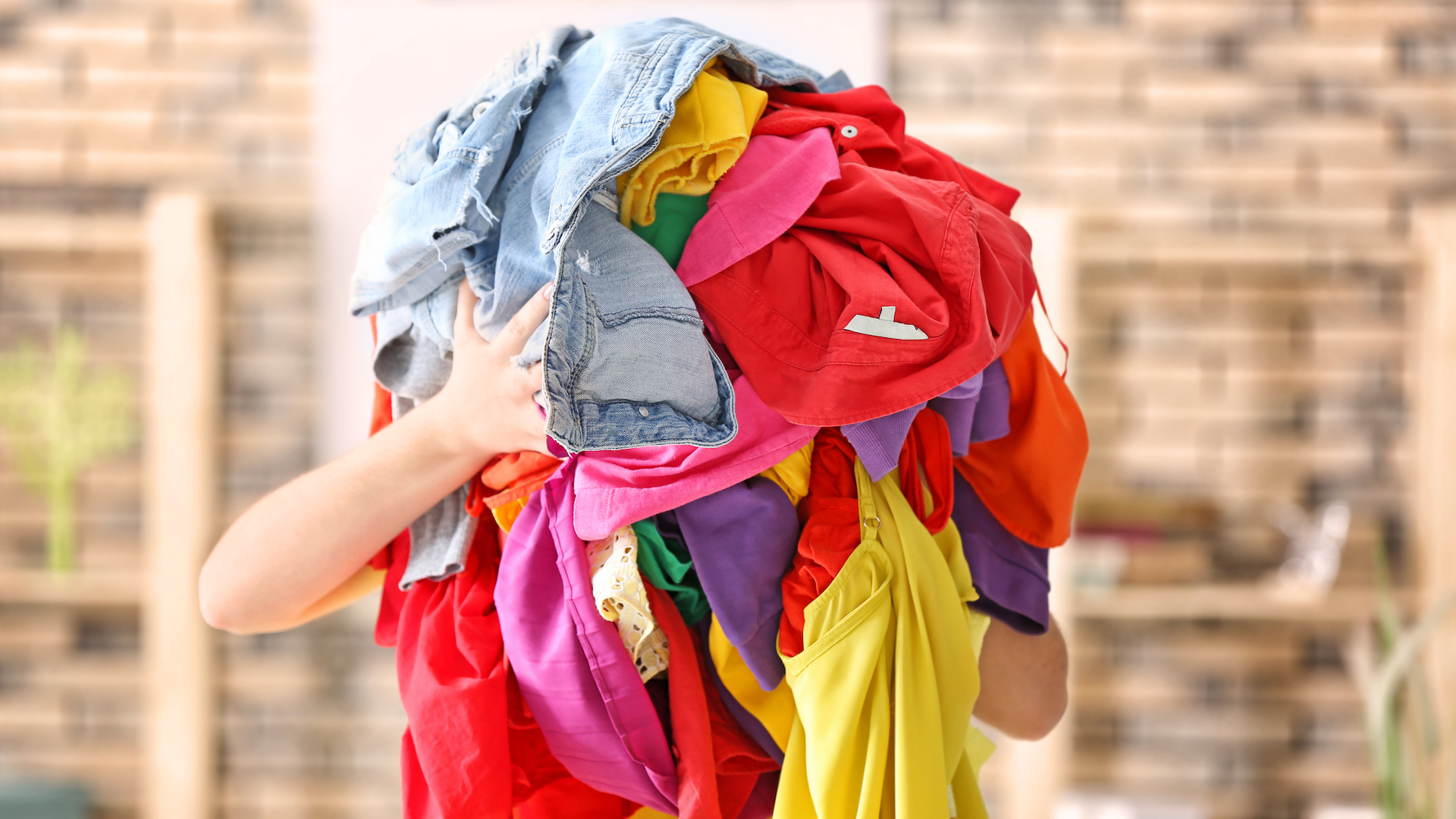 A person holding a pile of clothes