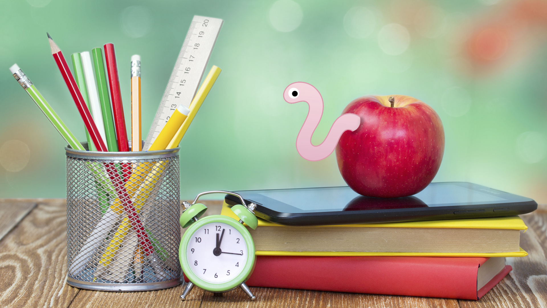 A worm poking out of an apple, next to a pile of homework