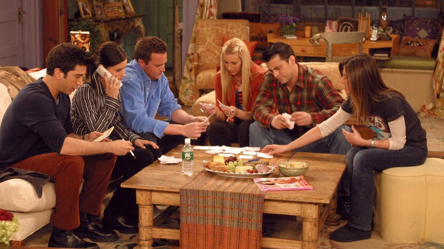 Friends cast all gathered around coffee table
