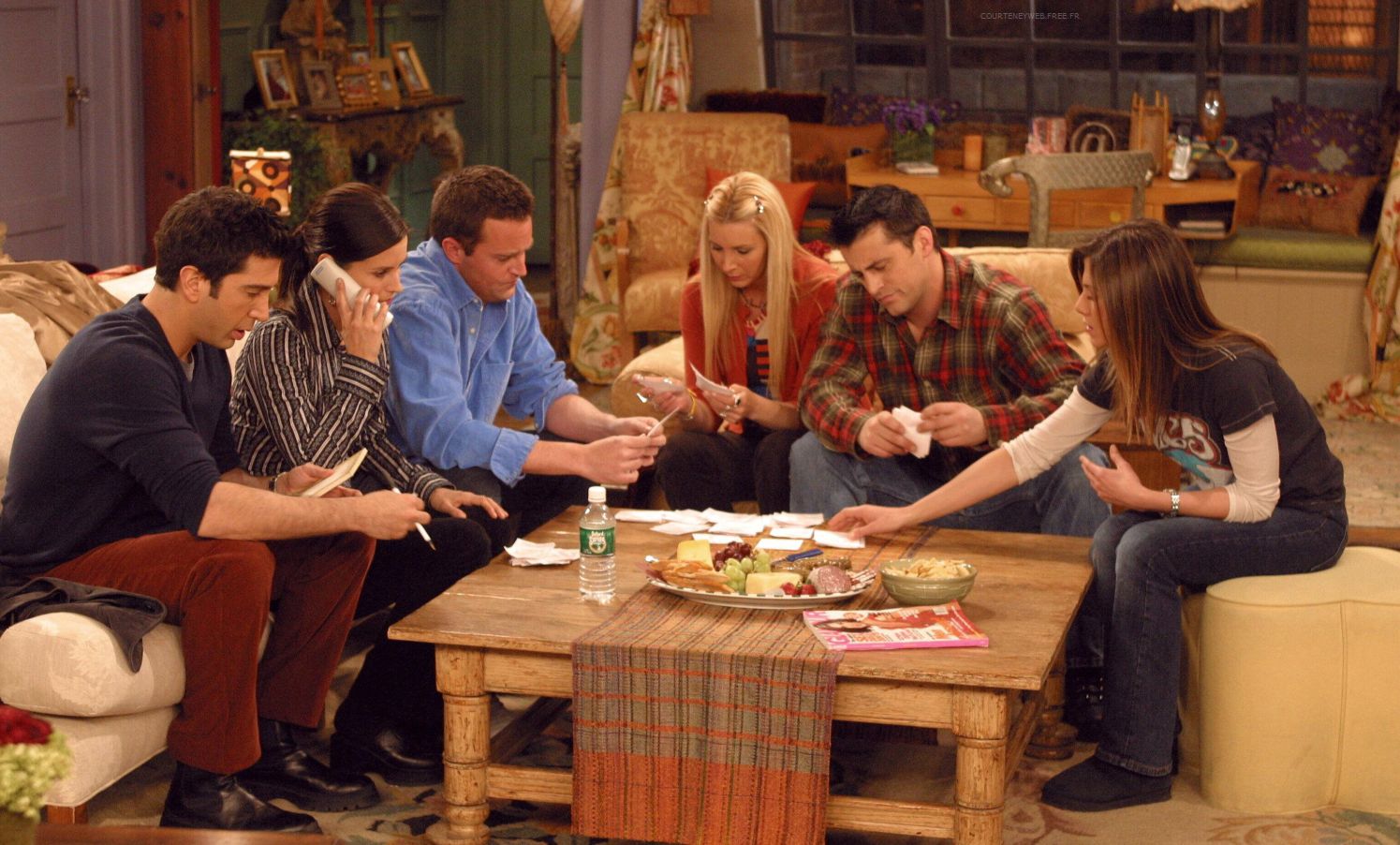 Friends cast all gathered around coffee table