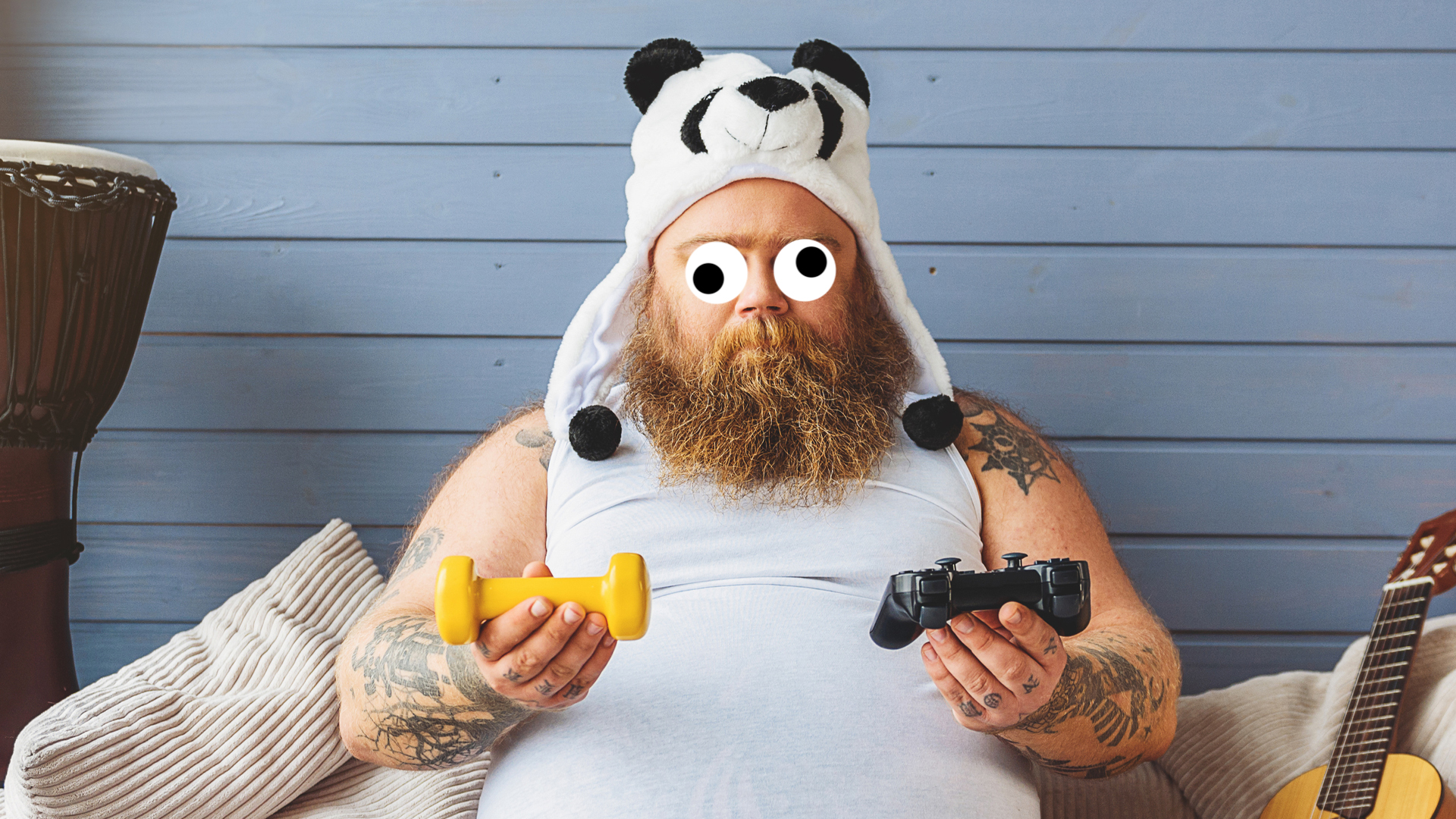 A man wearing a Panda hat holding two video game controllers
