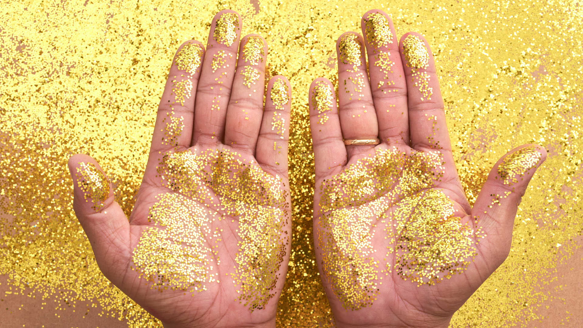Two hands covered in glitter