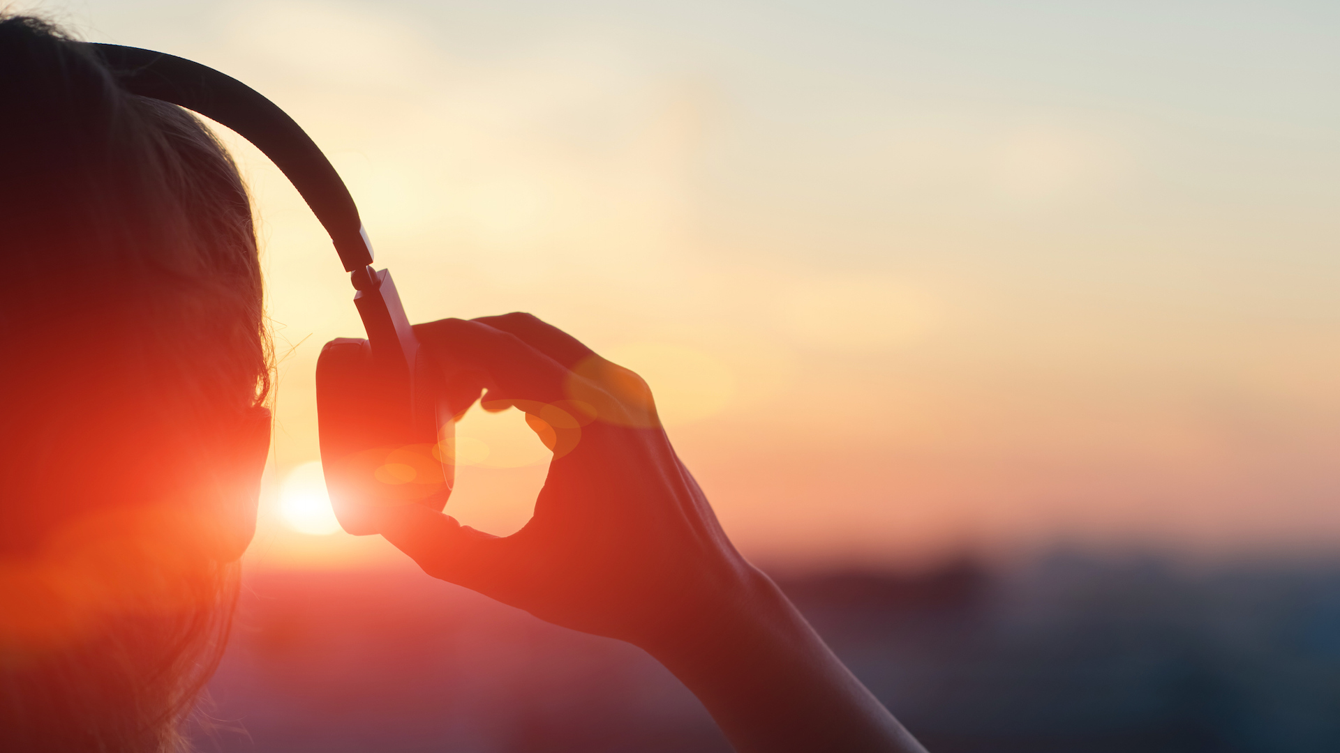 A person listening to music while the sun rises