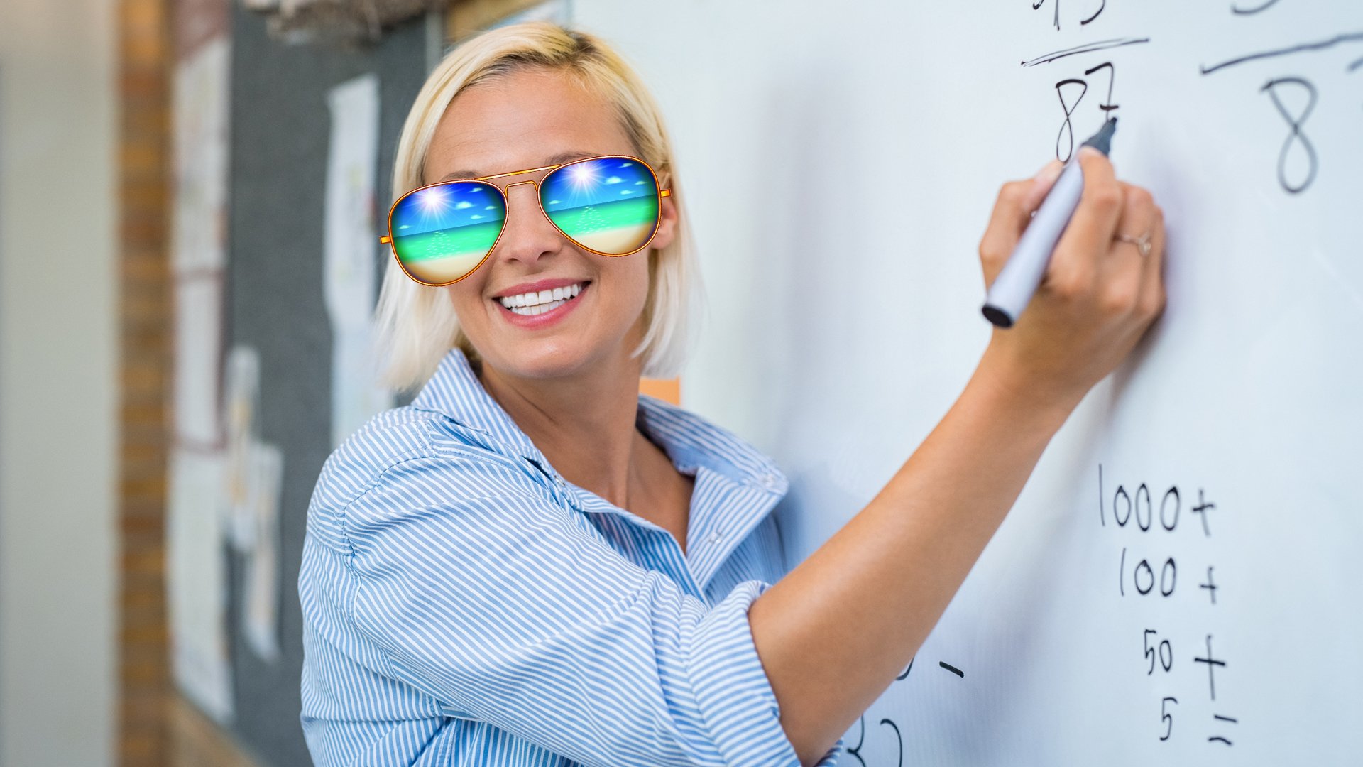 A teacher wearing sunglasses while writing on the wipe board 