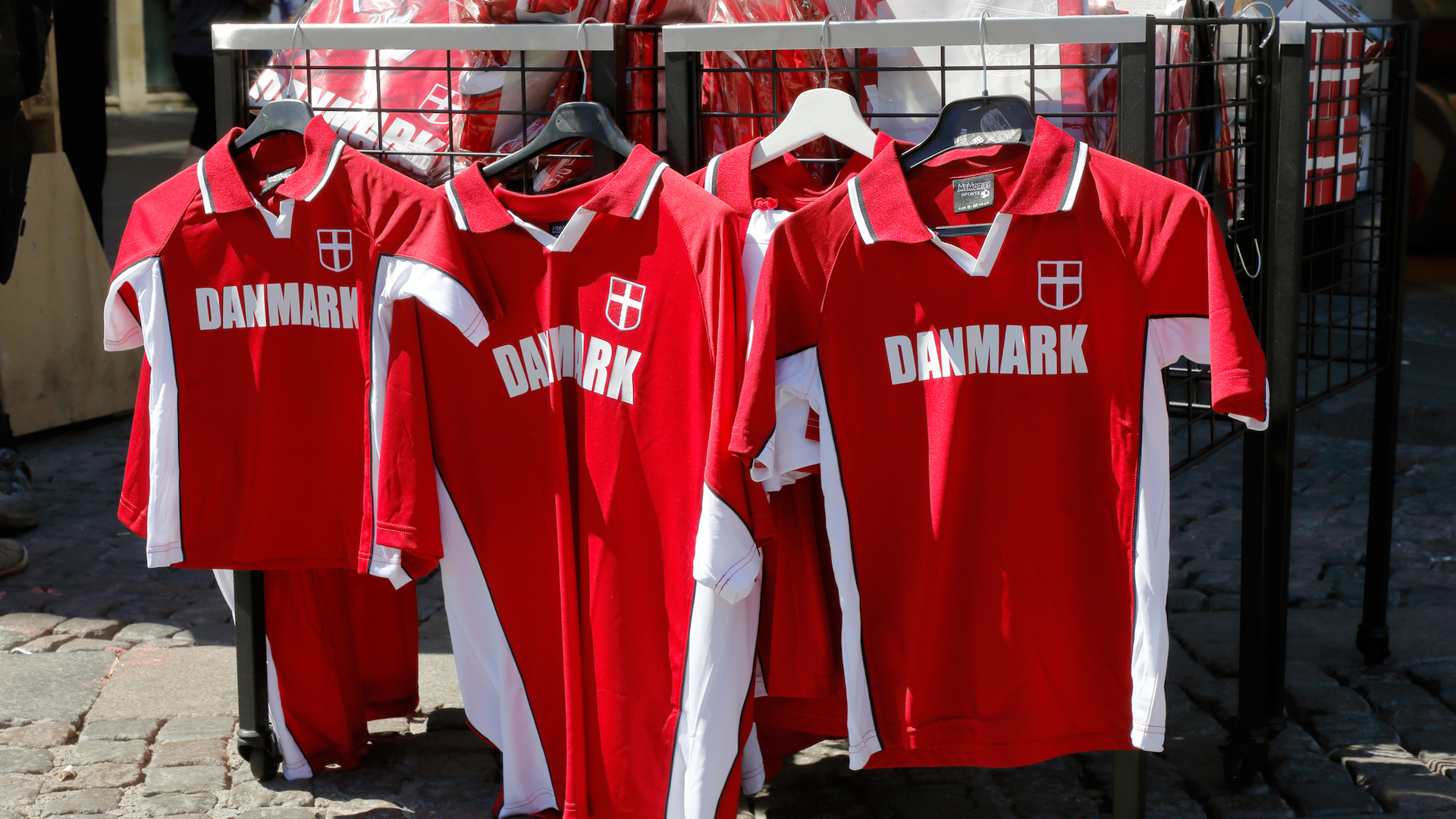 A selection of Denmark football shirts in a market