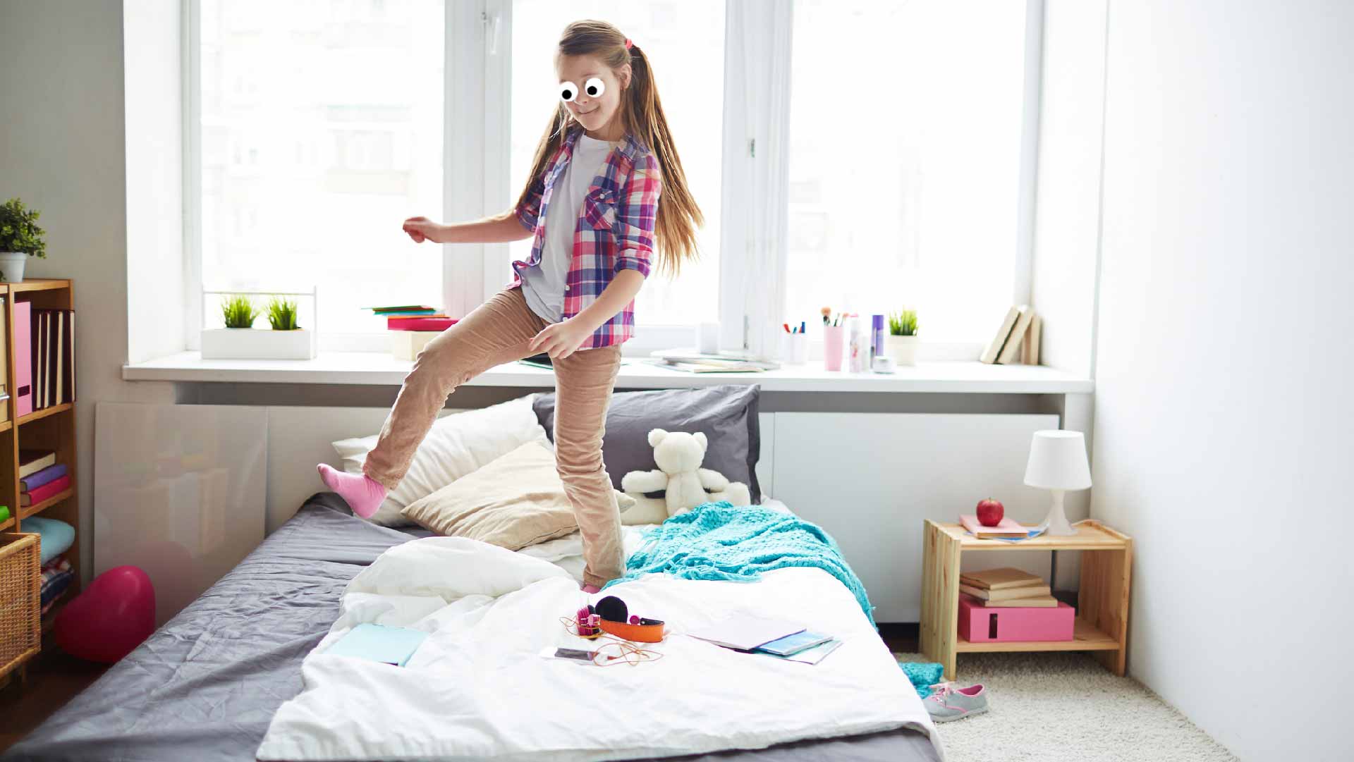 A child jumping on a bed in a tidy room