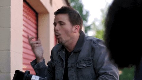 A gif of a man smelling something terrible