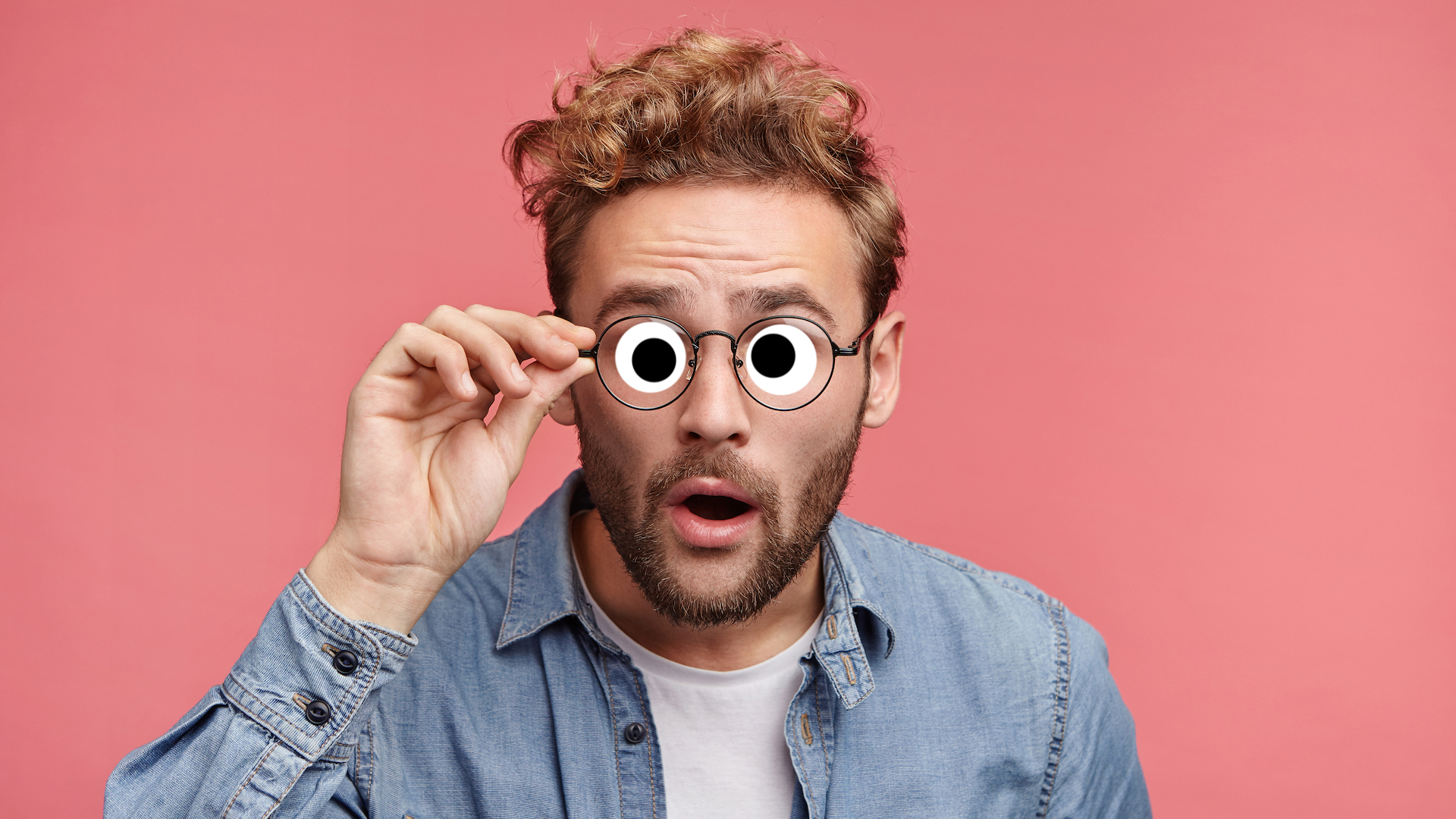 A man staring while holding his glasses