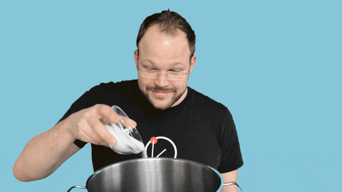 A man pouring salt into a big pan