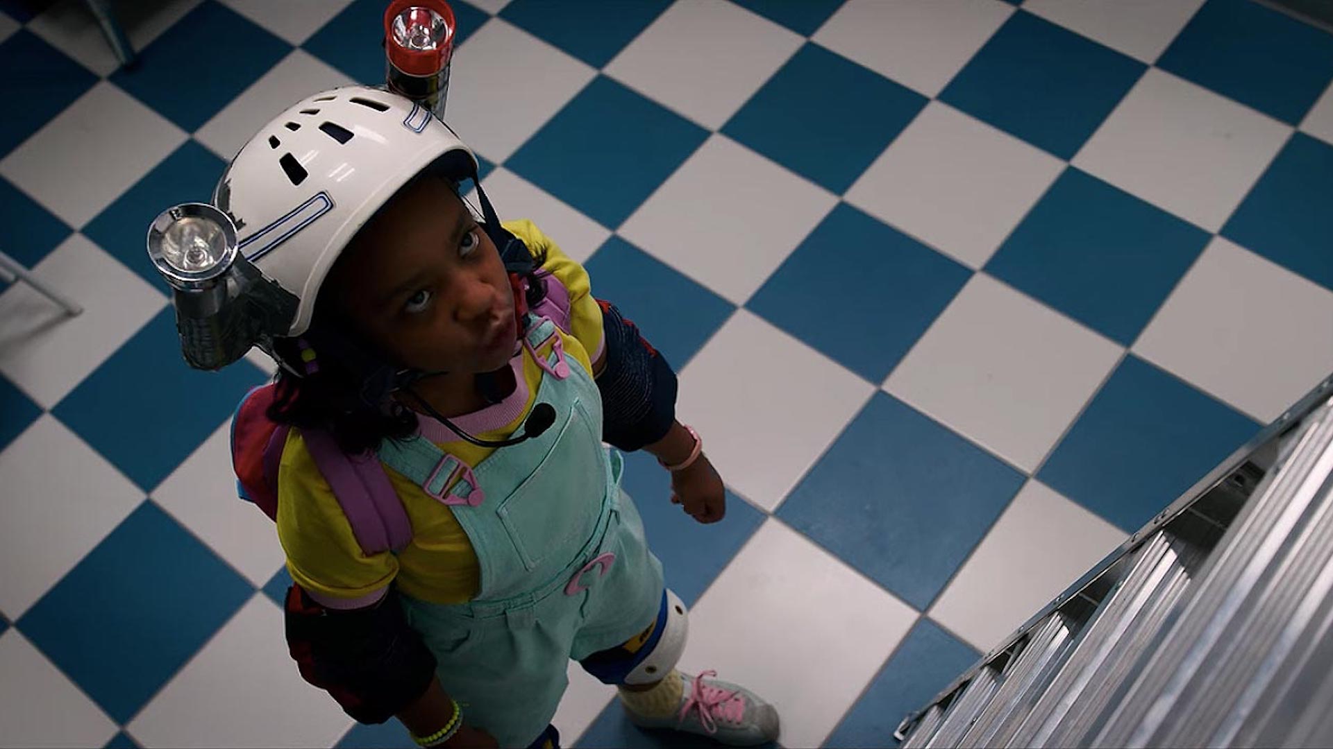 Erica looks up a big ladder in Stranger Things