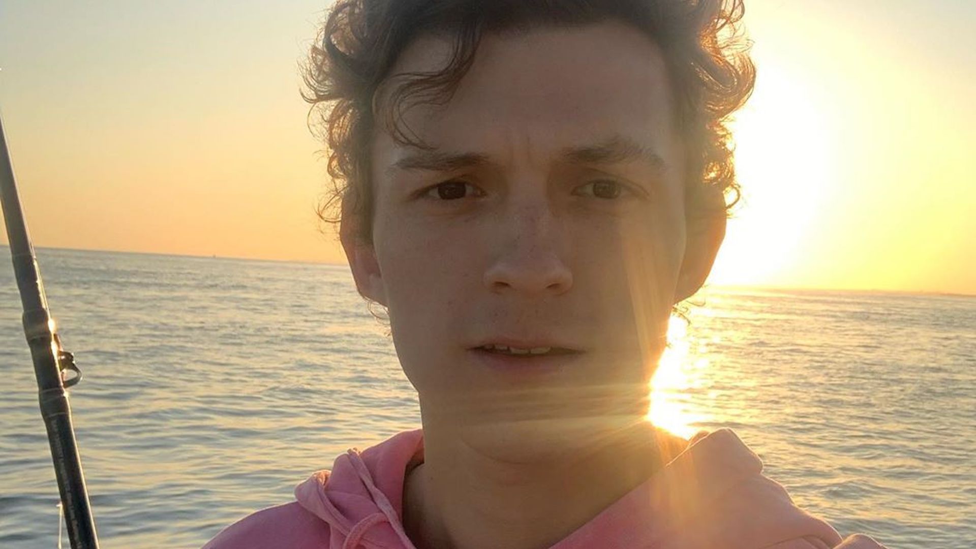 Tom Holland taking a selfie against a sunset