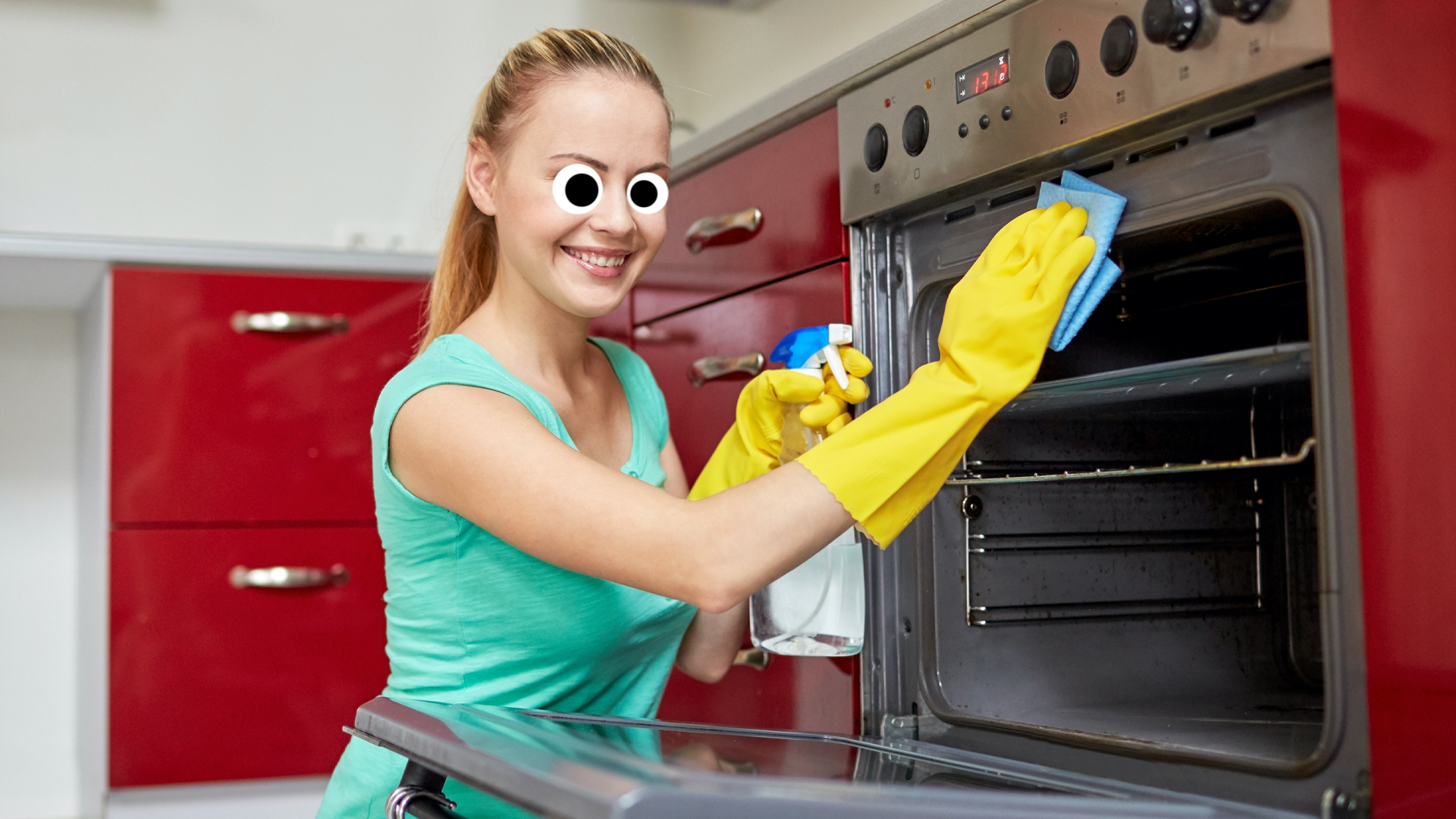 A woman smiling as she cleans an oven