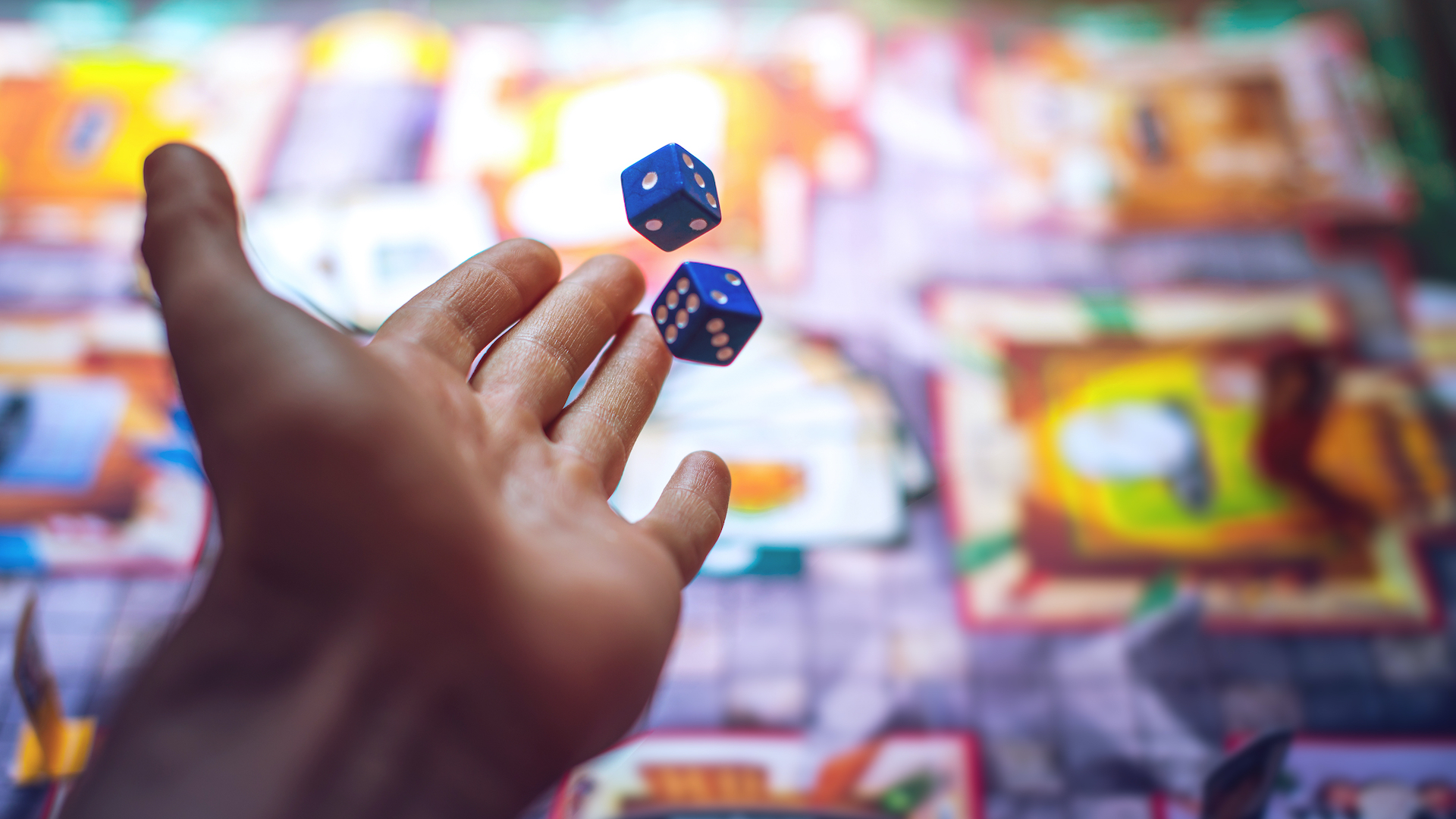 A person rolling the dice while playing a board game