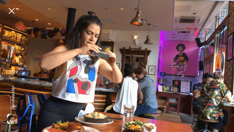 A woman dropping her phone into her dinner