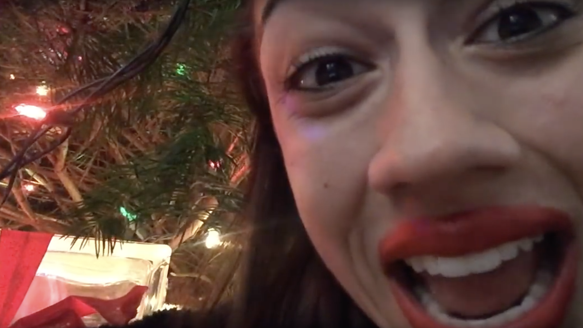 Miranda Sings in front of a Christmas tree