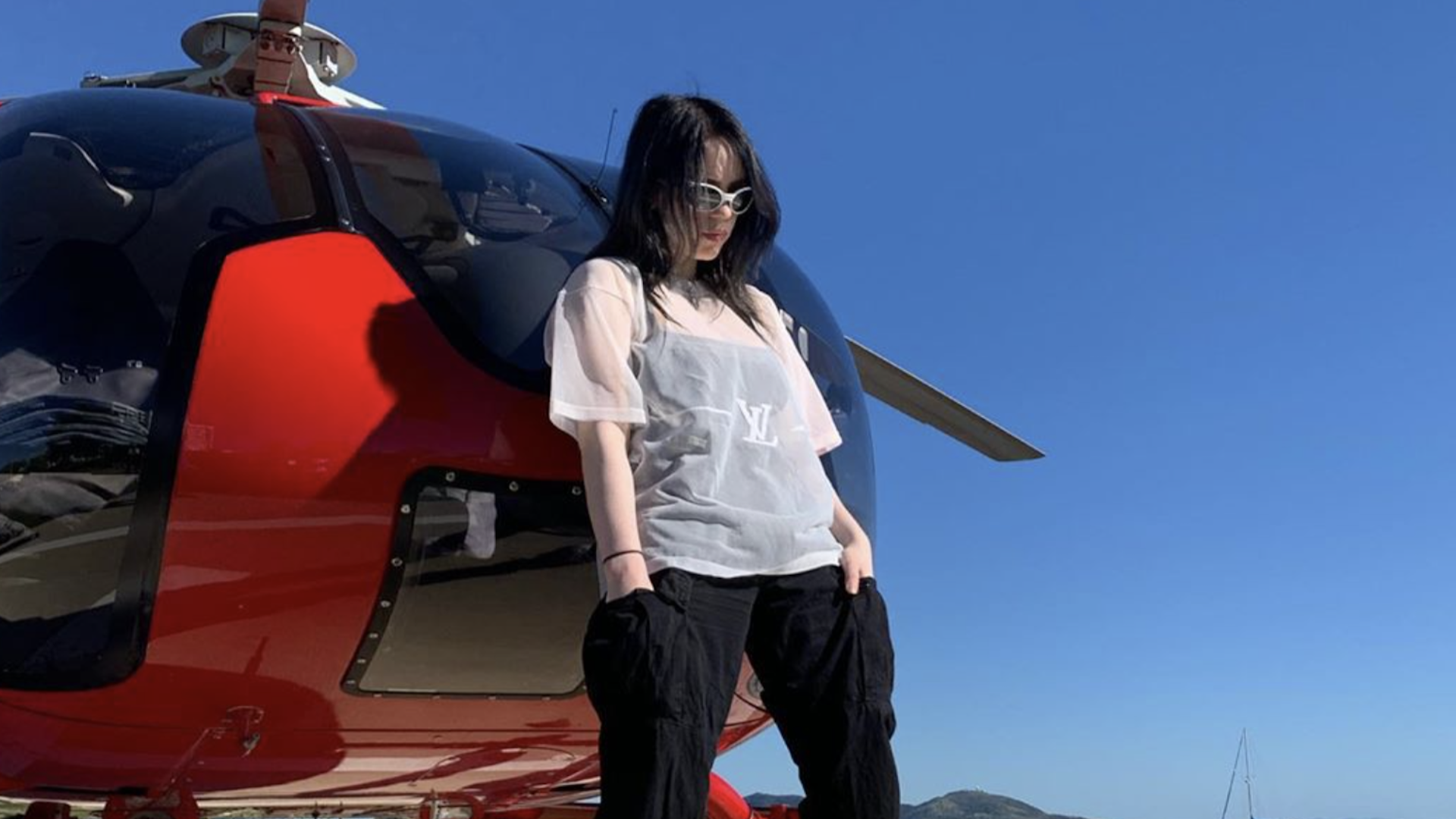 Billie Eilish standing next to a helicopter