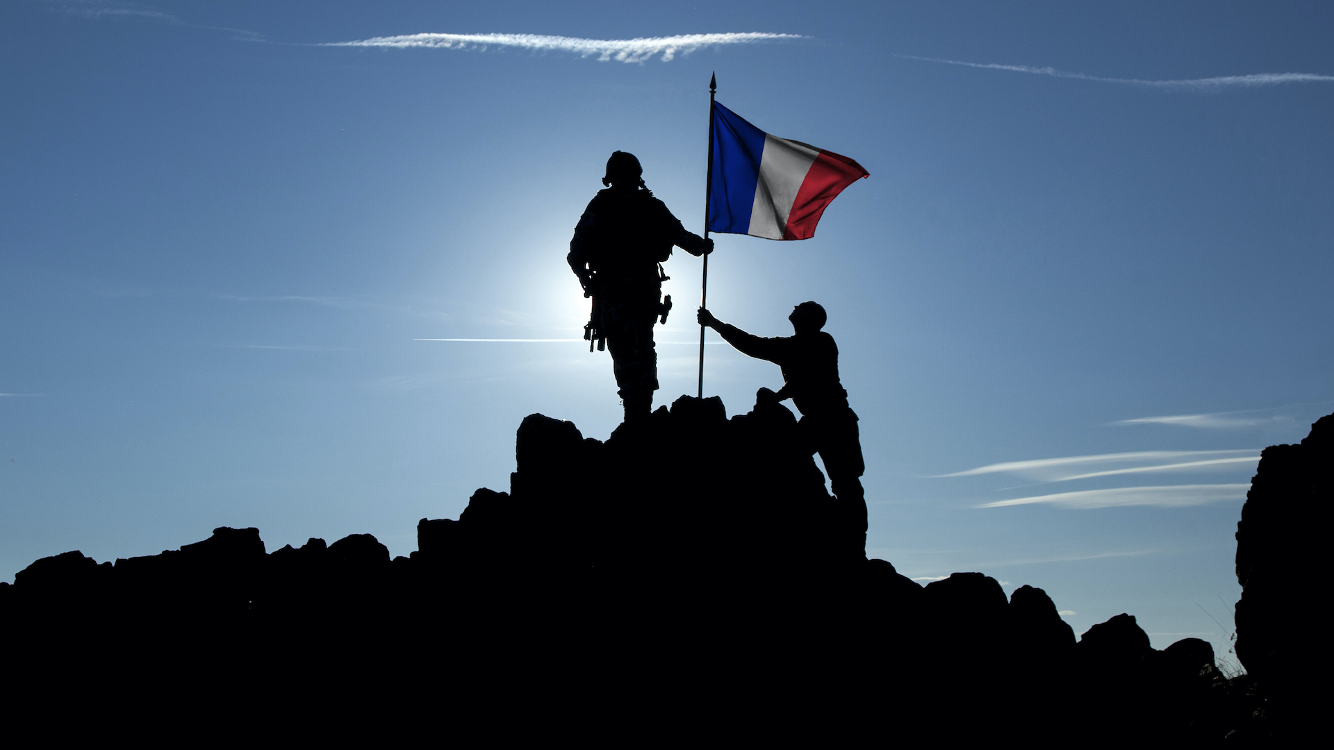 Two people raise the French flag