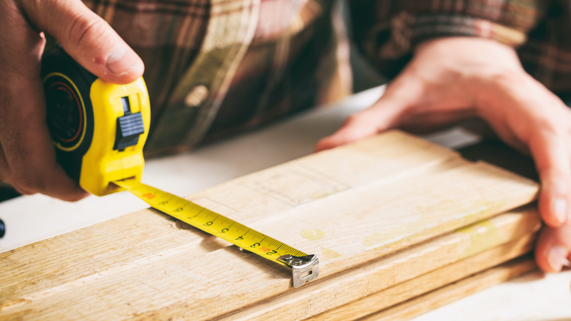 A carpenter measuring wood