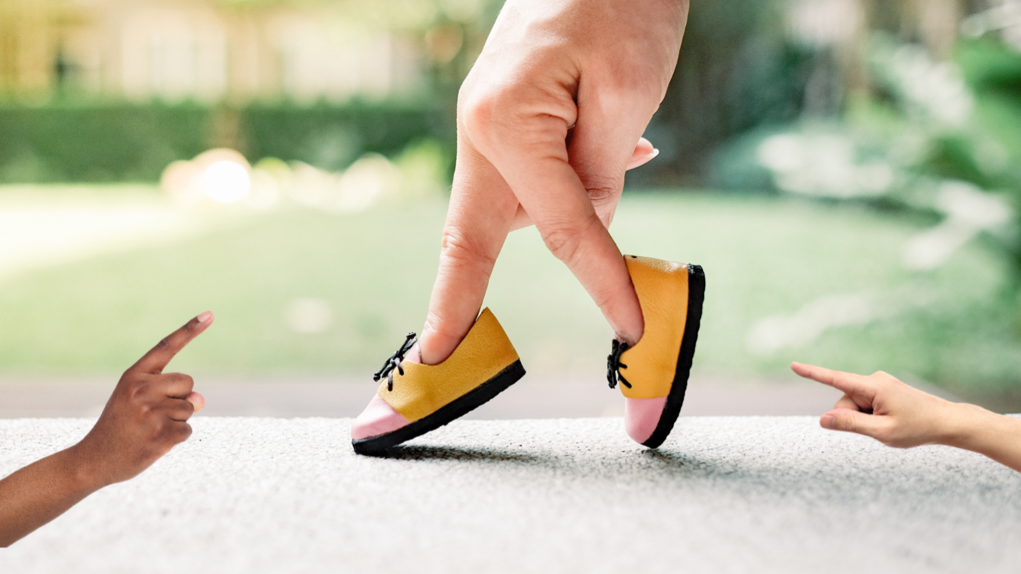 Two fingers wearing a pair of shoes and going for a stroll 