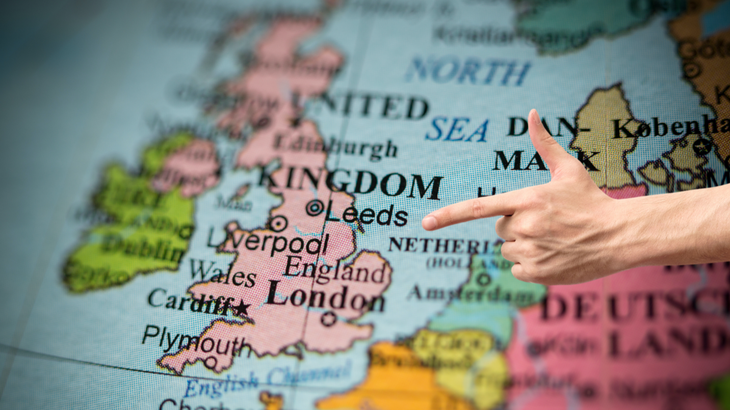 A finger pointing at a map of the UK