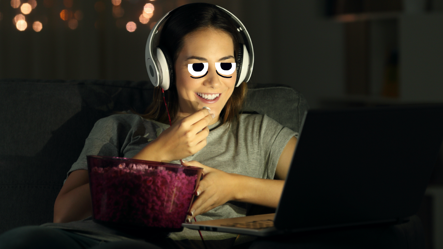 A woman watching a film and eating popcorn