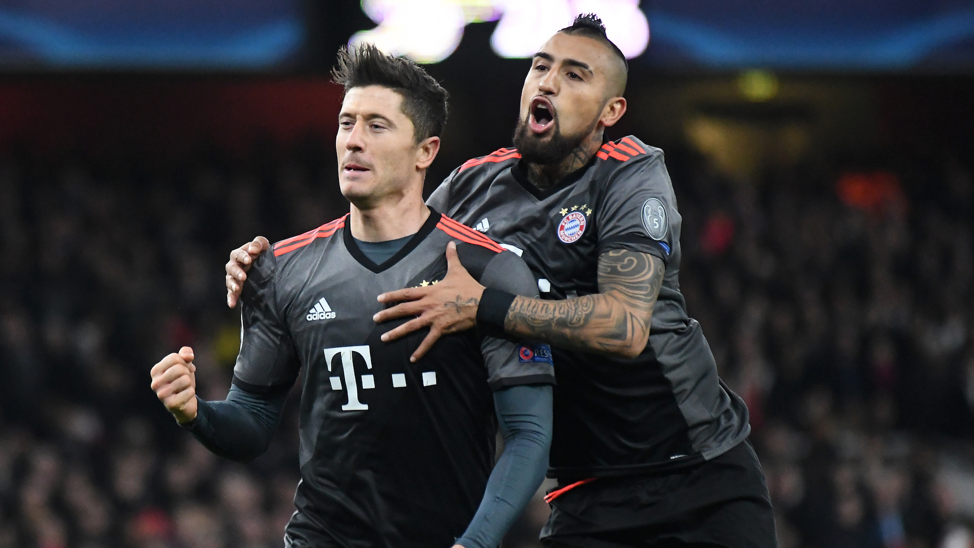 Robert Lewandowski and Arturo Vidal celebrate after a goal during the UEFA Champions League Round of 16 game between Arsenal FC and Bayern Munich at Emirates Stadium