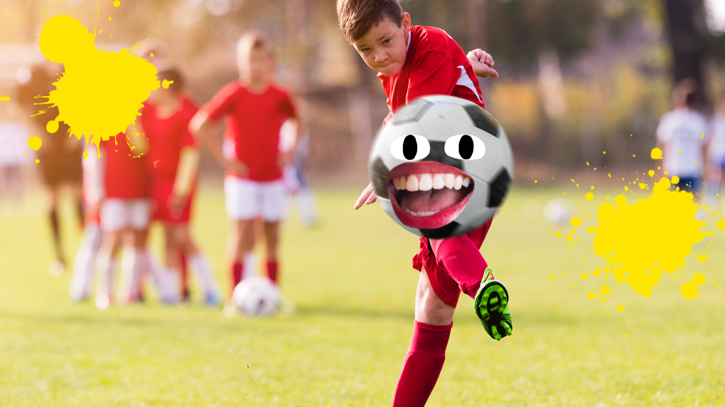 Boy kicking football while his teammates look on
