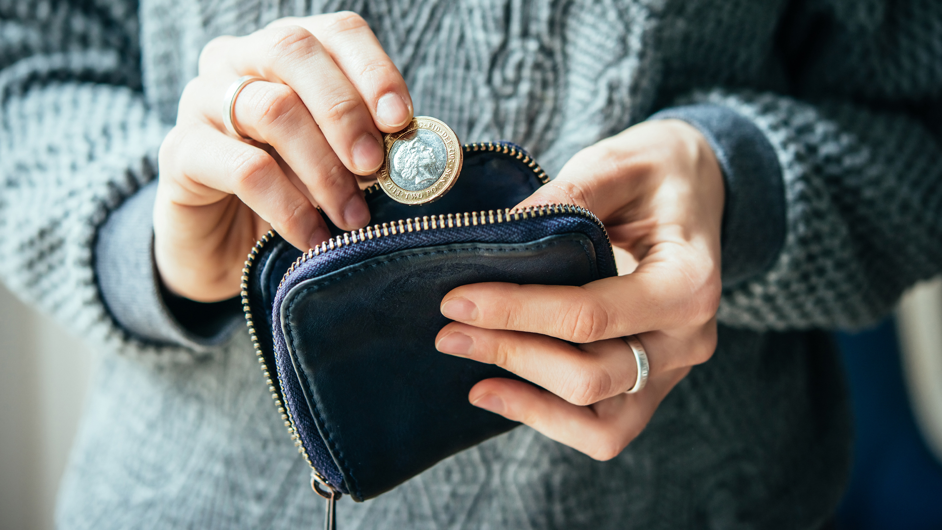 A person putting a coin in a purse