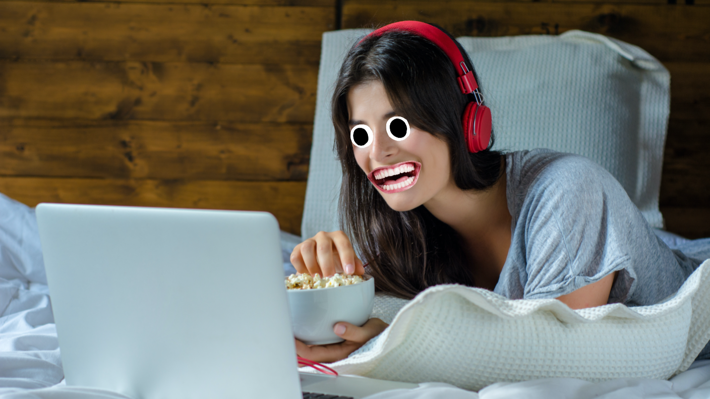 A person watching a film on their computer with some snacks