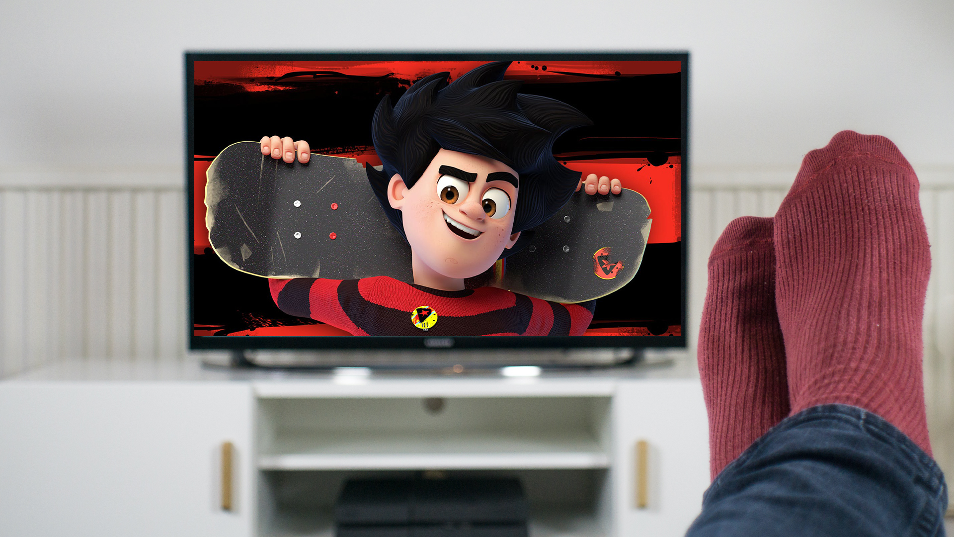Person with feet up watching Dennis and Gnasher Unleashed 2
