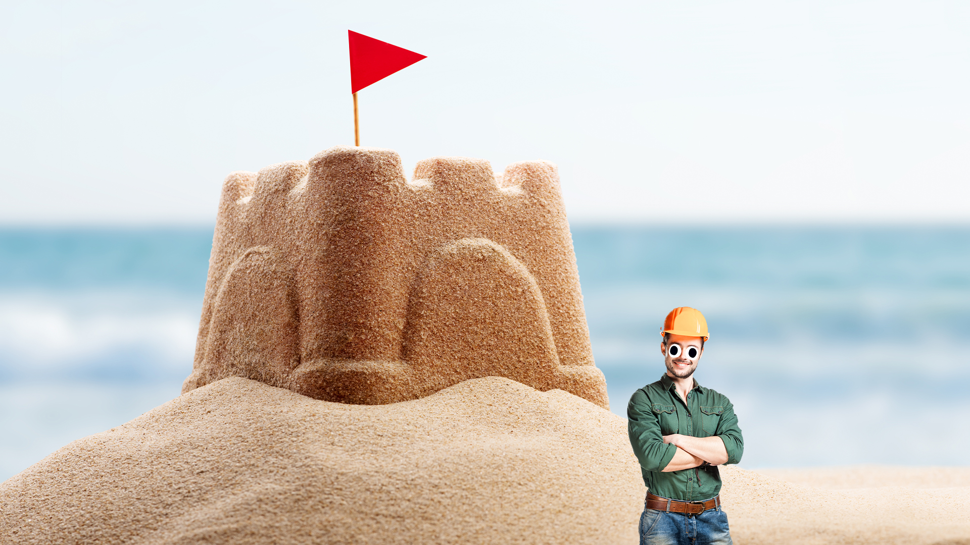 A big sandcastle and construction worker