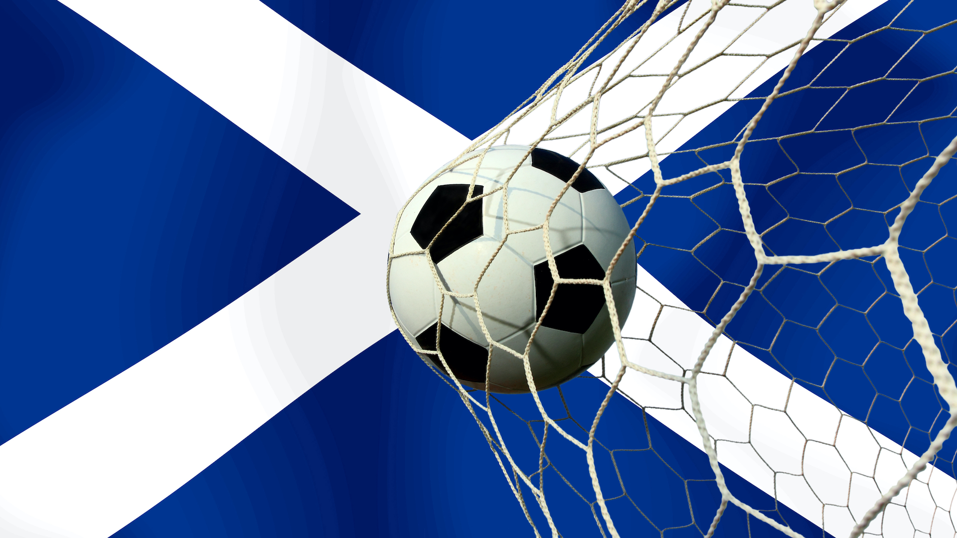 a football bursting the net in front of a Scottish flag