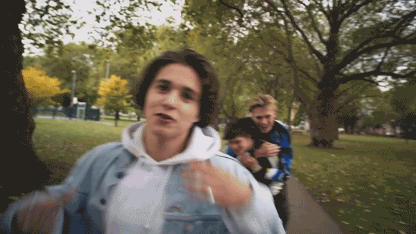 The Vamps in a park with a toilet behind them